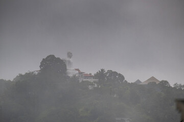 A view of the city of Kandy from the opposite shore of Lake Kandy, Sri Lanka. A historic Buddhist temple with a relic is located in this city. The rain begins during Hurricane Dilwa.