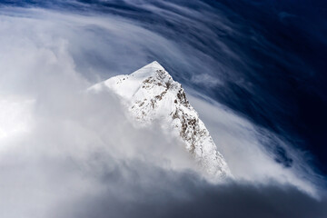 Snowy Mt. Nuptse summit in the clouds. View from Kala Patthar mount on Everest base camp trek in Khumbu, Nepal.