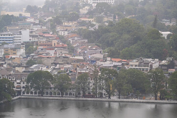 A view of the city of Kandy from the opposite shore of Lake Kandy, Sri Lanka. A historic Buddhist temple with a relic is located in this city. The rain begins during Hurricane Dilwa.