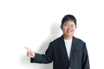 A chubby Asian boy in a suit is pointing to the side in the blank space for text.