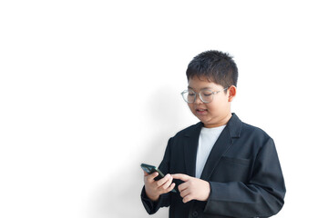 A chubby Asian boy in a suit is using a smartphone against a white background and workspace.