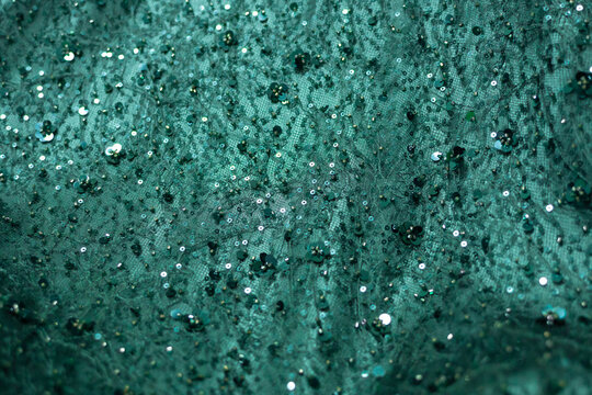 Lace, beaded, sequined green evening dress fabric stock photo