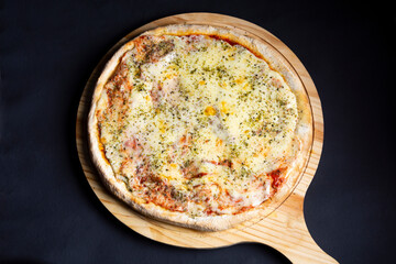 pizza de queso en tabla de madera en fondo negro
