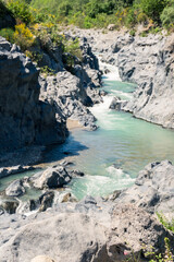 vertical photograph of Alcantara Gorges, a lava canyon formed by the Alcantara River with its basalt walls during a sunny day