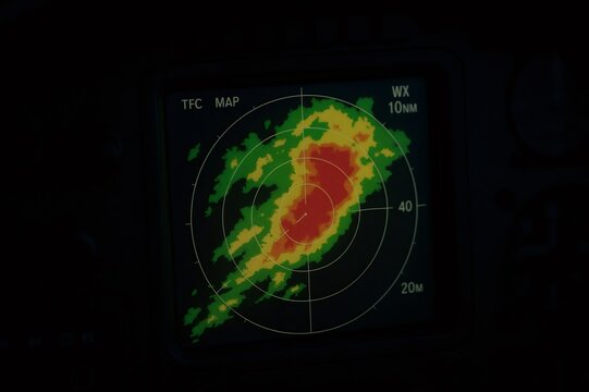 Cockpit display showing meteorological radar with storm cells, indicating bad weather on an aircraft navigation screen