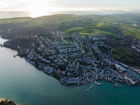 Aerial view of the town nestled between the Kingsbridge Estuary and rolling green hills, a tapestry of rooftops meeting the tranquil waters, Salcombe, England, United Kingdom.