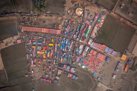 Bogura, Bangladesh - 10 February 2021: Aerial view of a vibrant marketplace, a kaleidoscope of colorful tents and bustling crowds, nestled amidst the tranquil fields.