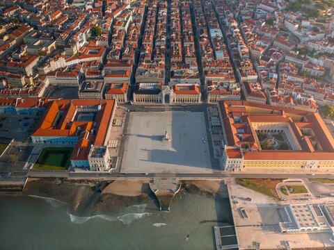 Aerial view of the vast Praca do Comercio square meeting the Tagus River's edge, a symphony of terra cotta roofs stretching into the horizon, Lisbon, Lisbon, Portugal.