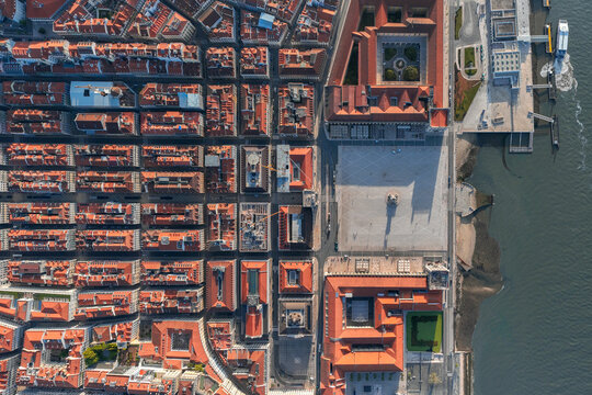 Aerial view of terracotta rooftops cascading towards the grand Praca do Com&eacute;rcio square, where the Tejo River reflects the sky, Lisbon, Lisbon, Portugal.