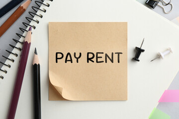 Pay rent. Paper note with text and other stationery on table, top view