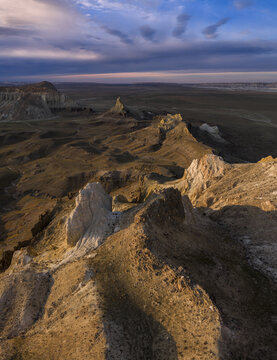 Aerial view of rugged terrain sculpted by time under a sky brushed with twilight hues, Shetpe, Mangystau Region, Kazakhstan.