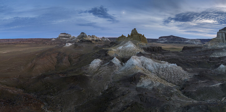 Aerial view of the stark, rugged landscape with white-capped rock formations under a dramatic sky, Shetpe, Mangystau Region, Kazakhstan.
