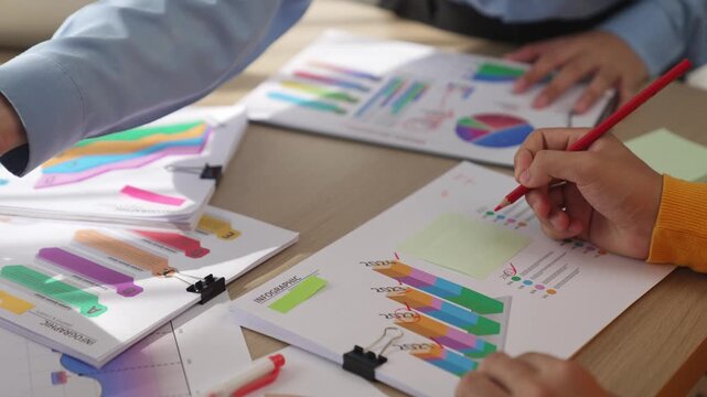 Startup company employee work together, analyze colorful BI dashboard paper with financial data reporting and planning strategic, marketing for creative business success in panorama video. Synergic