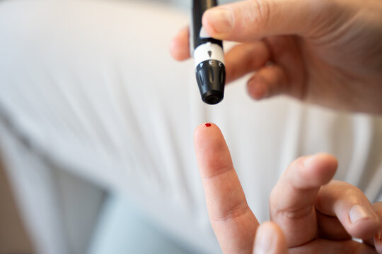 Close-up of a person testing blood sugar with a lancet