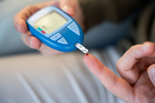 Person checking blood glucose level with glucometer