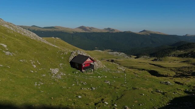 Cinematic 4K Aerial Low Altitude Approach to Wooden Refuge Saua Strunga Bucegi Mountains Revealing Eastern Ridge Peaks