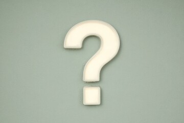 Question mark displayed on a simple wall surface in a soft design