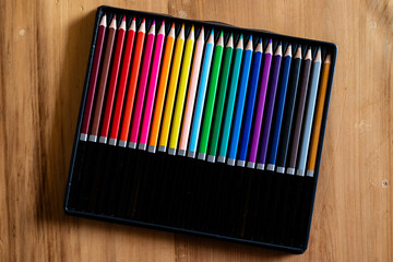 Packet of color pencils on wooden table. Art supplies concept.