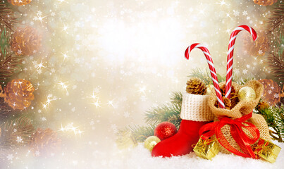 Christmas background with decorative Santa's red boot, candy cane lollipop and gift bag, branch and pine cones for tree decoraton. New Year winter holidays fantasy concept with decor and copy space.