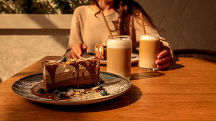 Decadent chocolate layered cake with fresh blueberries and latte art coffee drinks