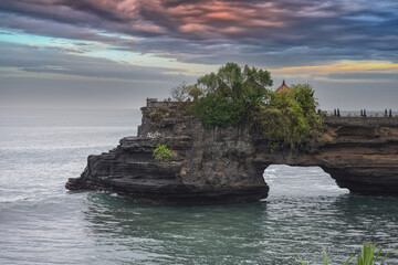 The natural rock arch at the Pura Batu Bolong near Tanah Lot Temple in Bali, Indonesia