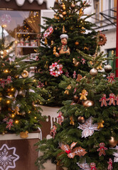A Christmas tree decorated with gingerbread men and red bows on the city streets
