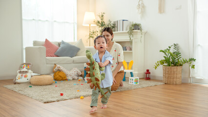 Boy Takes His First Steps at Home While Holding His Mother's Hand in a Warm Living Room Setting