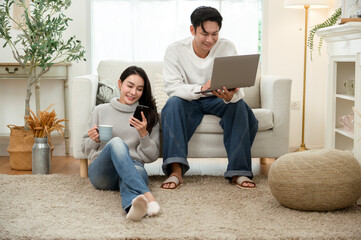 Couple Relaxing at Home in Winter While Using a Laptop and Enjoying Drinks Together