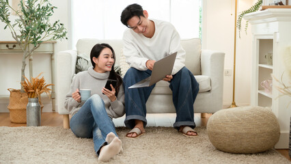 Couple Relaxing at Home in Winter While Using a Laptop and Enjoying Drinks Together
