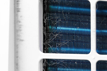 Contaminated heat exchanger and cooling fins inside a residential air cleaning device covered with trapped dust particles 