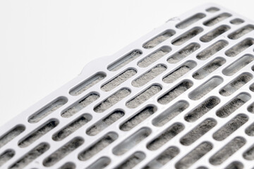 Dust clogged in the air filter cartridge cells on a white table. Used spare part.