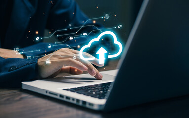 A professional uses a laptop with a glowing cloud upload icon, representing cloud computing, data storage, file synchronization, digital transformation, and secure online infrastructure.