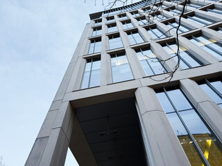 Low angle view of a tall modern office building in Manchester UK with glass fa&ccedil;ade and urban architecture