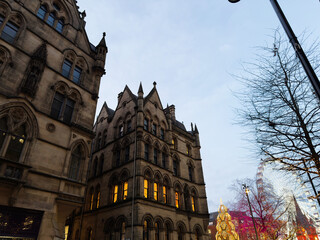 Historic Gothic architecture in Manchester city centre at Christmas with festive lights and tree