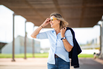 Smiling woman in sunglasses enjoying a sunny day outdoors