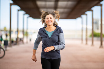 Happy senior woman jogging outdoors