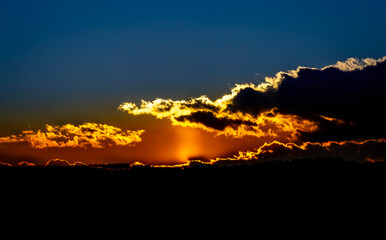 Dramatic sunset background with cloudy sky.