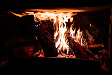 Fireplace with log fire in living room, cozy and warm home	