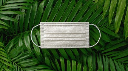 Surgical face mask resting on a vibrant green palm leaf providing protection and promoting health in a natural setting