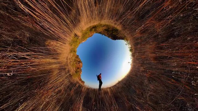 Hiker walking in nature on tiny planet landscape
