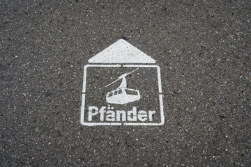 Markierung und Wegweiser auf Asphalt zum Abfahrtsort der Seilbahn, Pf&auml;nderbahn zum Gipfel des Berges Pf&auml;nder in Bregenz in &Ouml;sterreich 