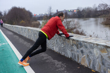 a man is exercising and running on a track next to a river