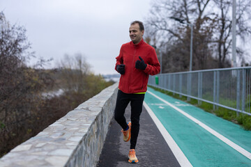 a man is exercising and running on a track next to a river