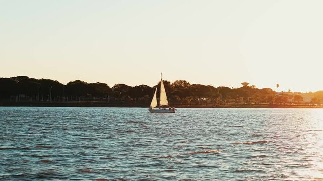 Velero navegando por las costas de Federacion, Entre Rios en la hora dorada