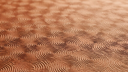 Close up of textured terracotta background featuring repeating concentric spiral patterns in warm earthy brown tones with shallow depth of field effect