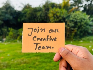 We are hiring trendy card post holding by hand, Join our team recruiting message, Drop your CV sticky note message, Vacancy here image