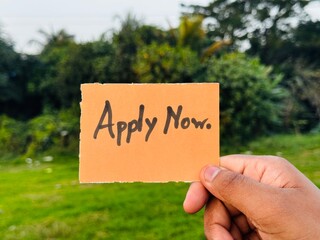 Apply now handwritten note, Apply now colorful sign on hand