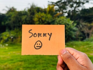 Sorry handwritten note, Sorry sticky note holding by a man