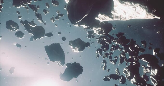 Numerous asteroids float in space, illuminated by bright light. The rough surfaces and varied sizes create a stunning contrast against the dark background of the universe.