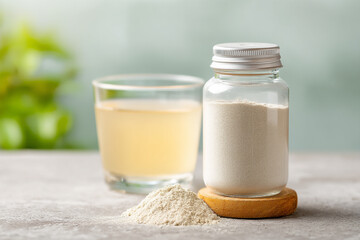 A generic bottle of oral rehydration solution (ORS) powder, with a blurred glass of mixed solution nearby, for recovery.